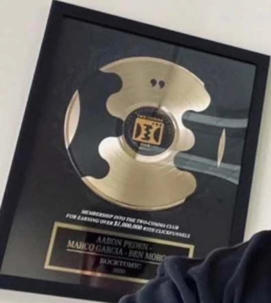 Rocktomic’s Two Comma Club plaque photographed with Aaron